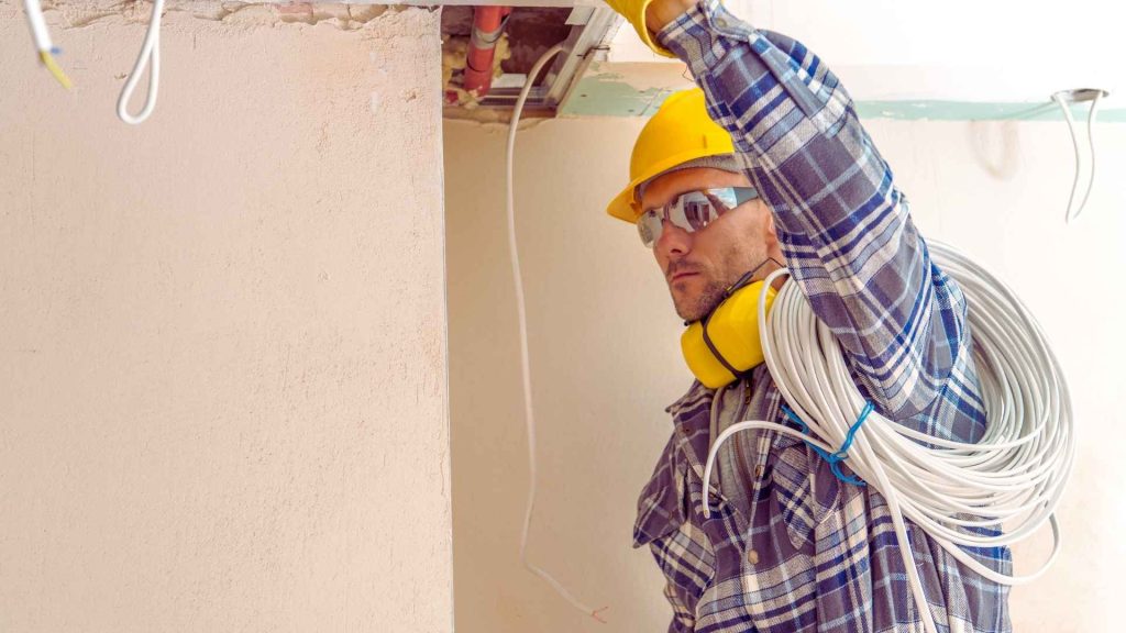 Elektricien trekt kabels tijdens renovatie – voorbeeld van werk van installateurs op de branchepagina van AVB Digital.